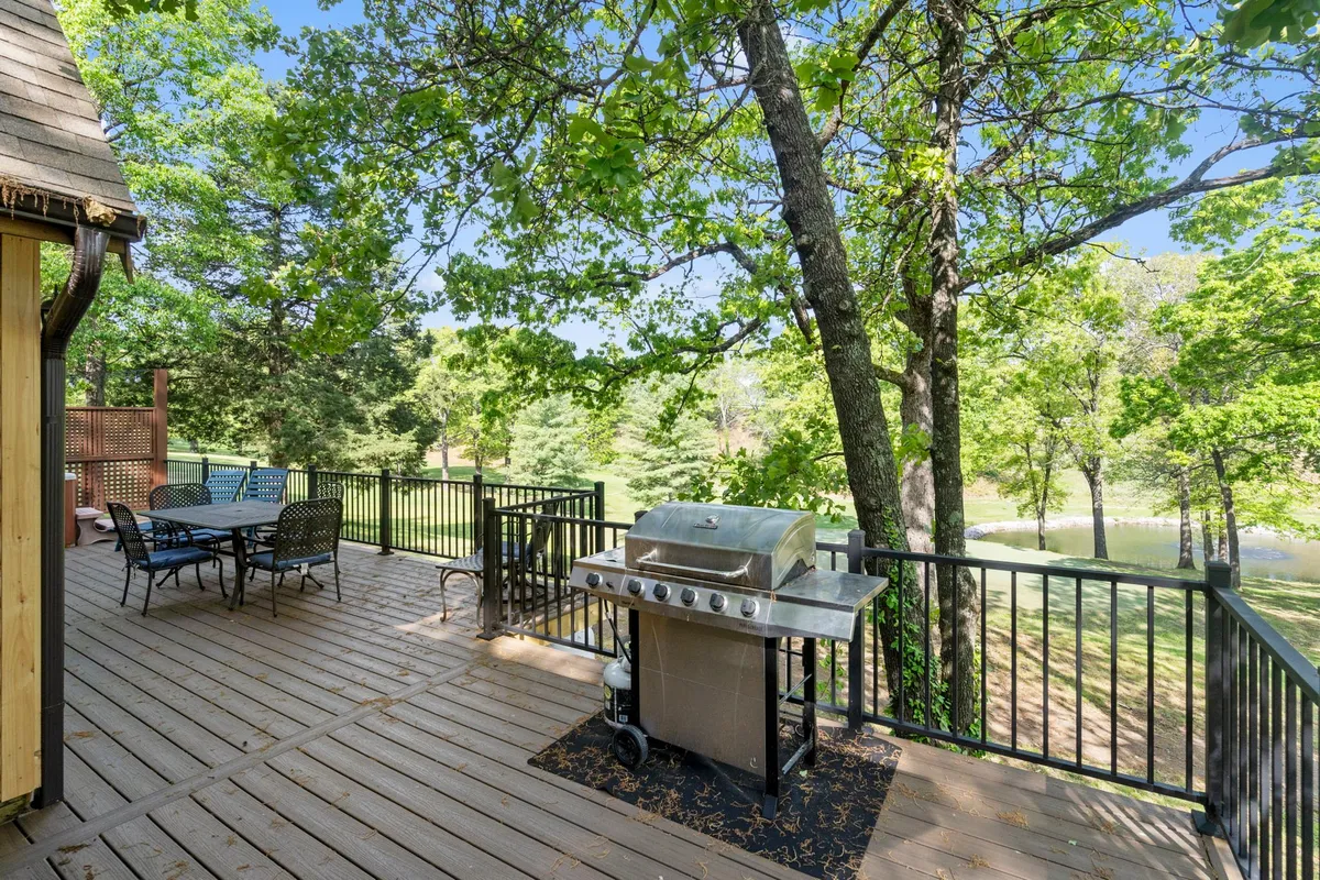 A relaxed outdoor dining setup with a grill and patio table nestled among tall trees. The setting is casual and intimate, ideal for both morning coffee and evening barbecues, emphasizing the joy of outdoor meals and gatherings.
