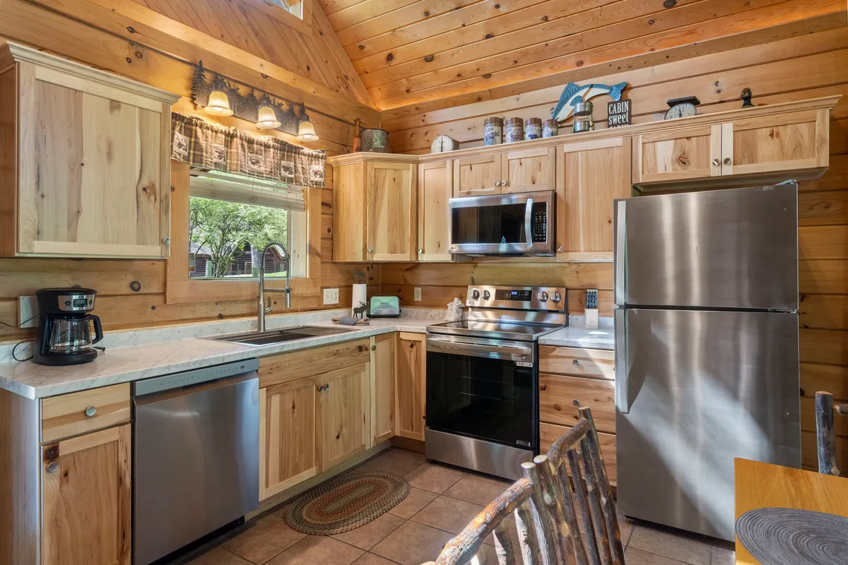 A bright and inviting kitchen with wooden cabinetry, stainless steel appliances, a central island, and a sunlit window. The setup is perfect for preparing anything from quick breakfasts to celebratory dinners, as highlighted in the narrative.